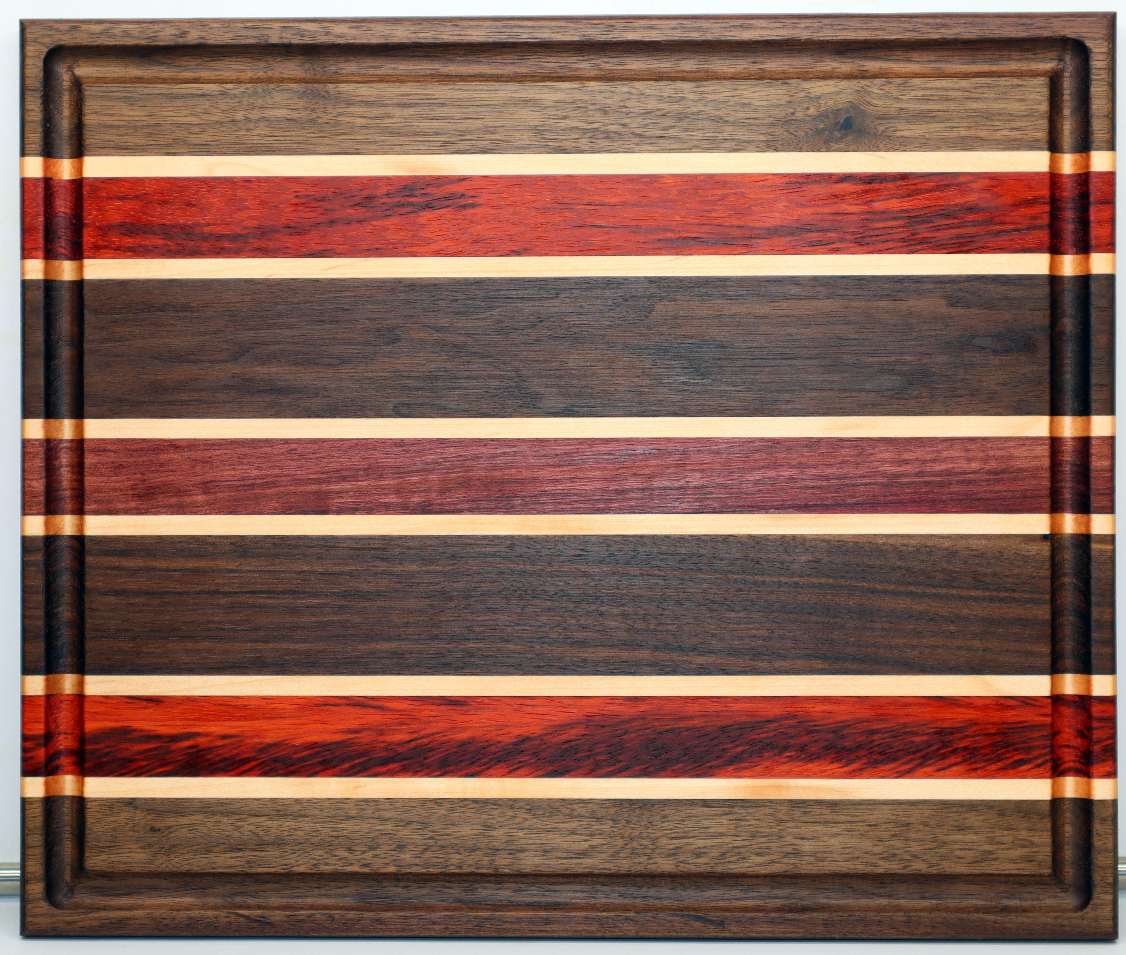 Custom hardwood cutting board with walnut, maple, and padauk